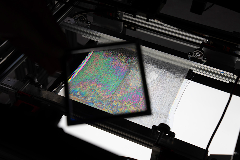 polarized filter held over polymer item to show stresses